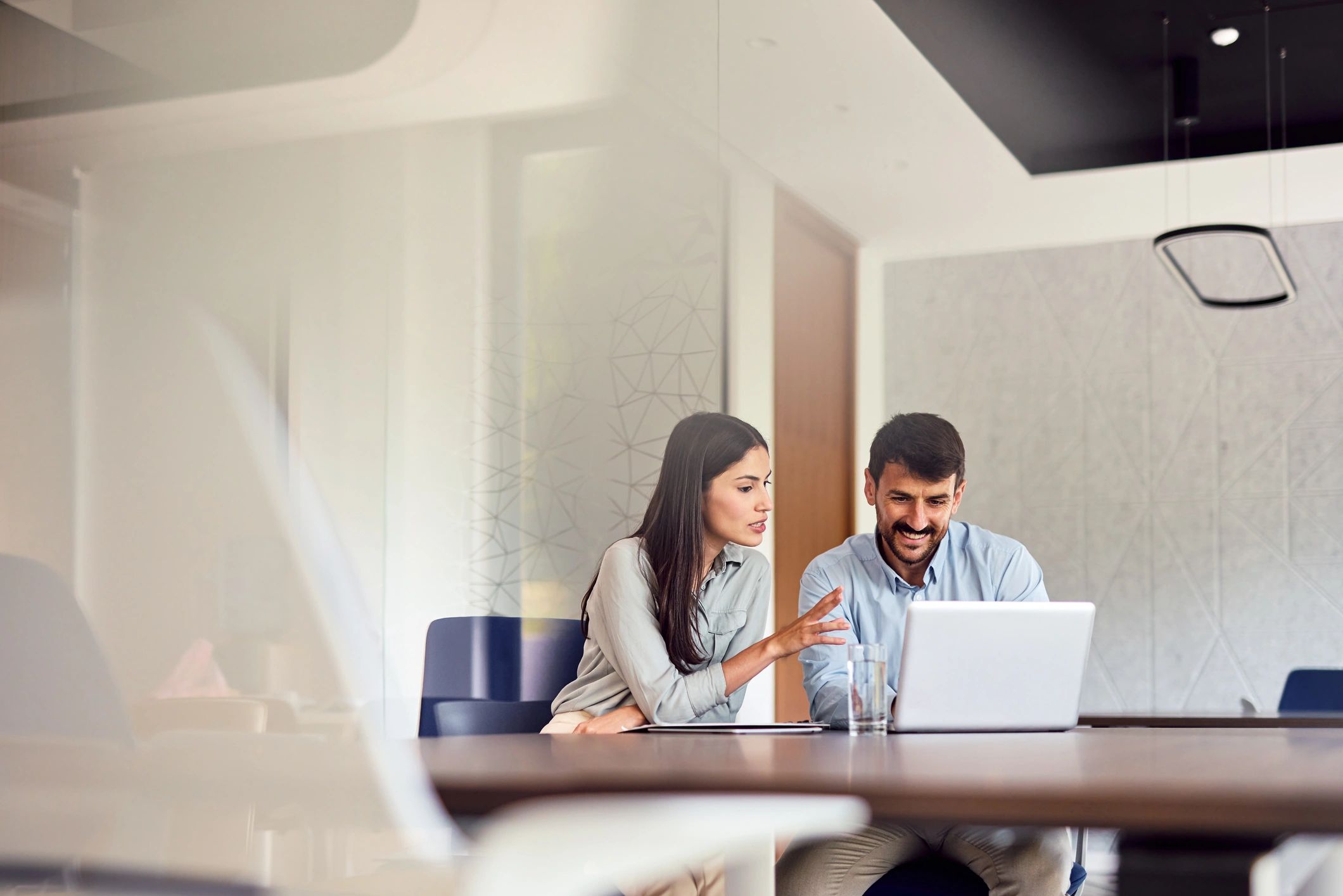 Two support professionals collaborating over a laptop